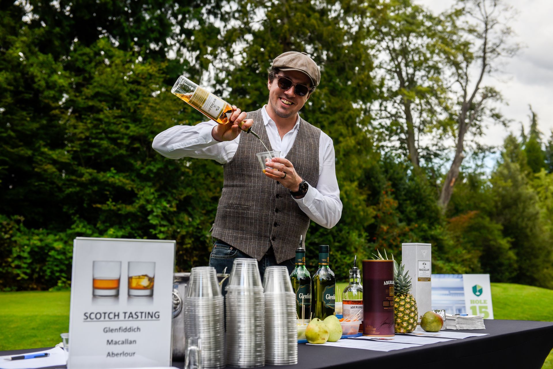 A man is pouring a drink from a bottle into a glass.