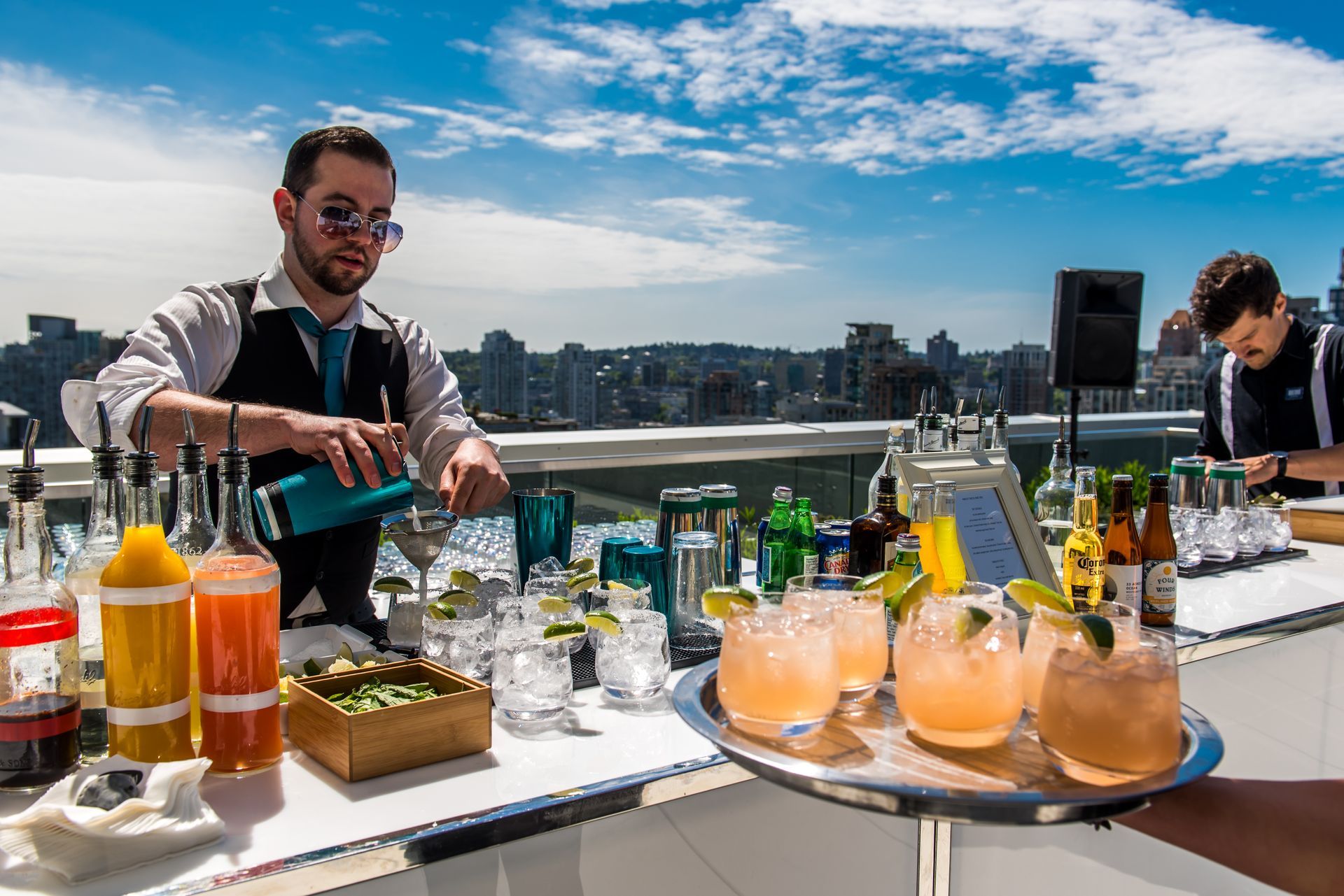 A man is pouring a drink into a glass at a bar.
