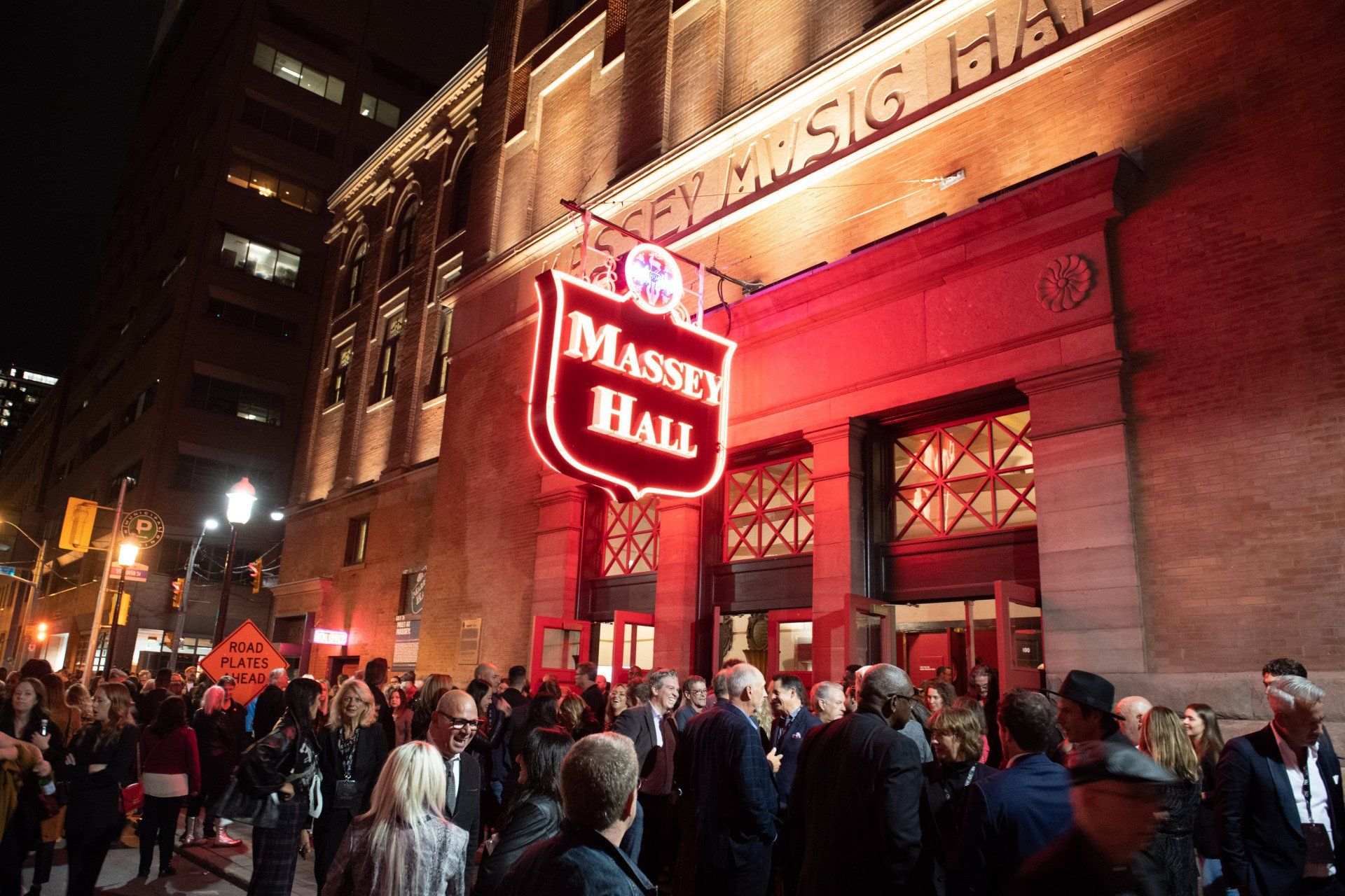 A crowd of people are gathered outside the massey hall