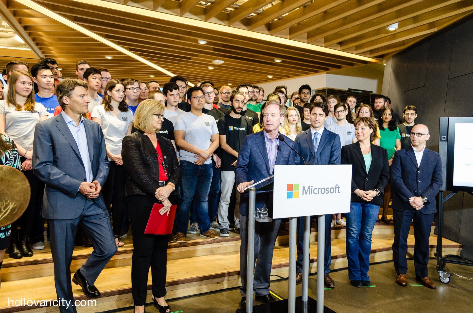 A group of people standing around a podium with a sign that says microsoft.