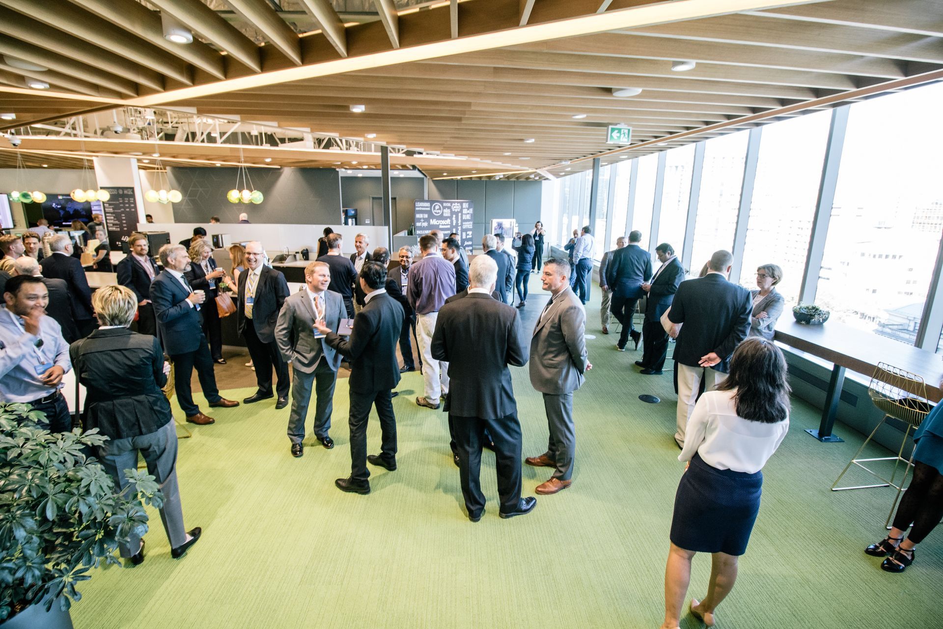 A group of people are standing in a room talking to each other.