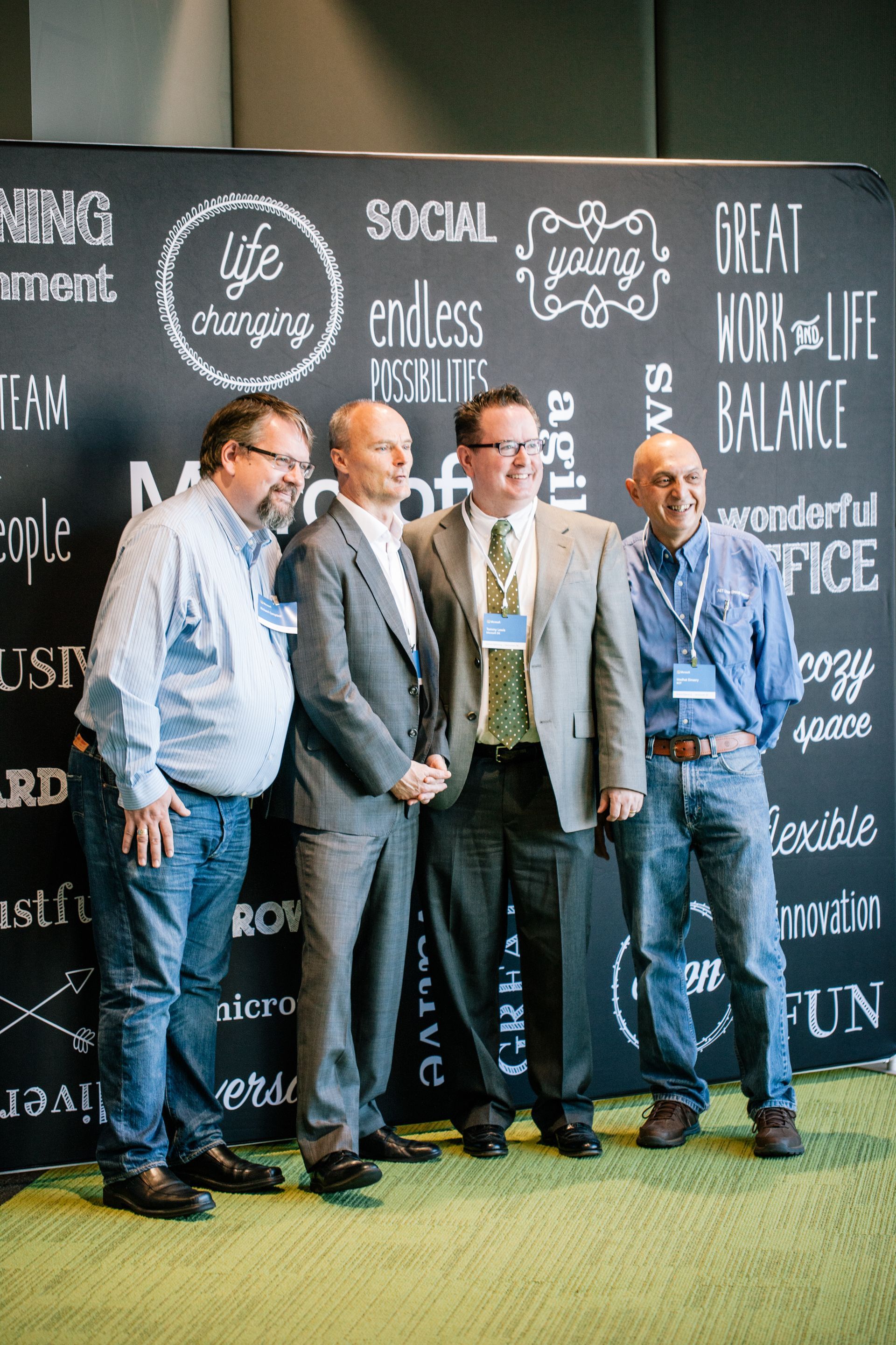 A group of men are posing for a picture in front of a blackboard.
