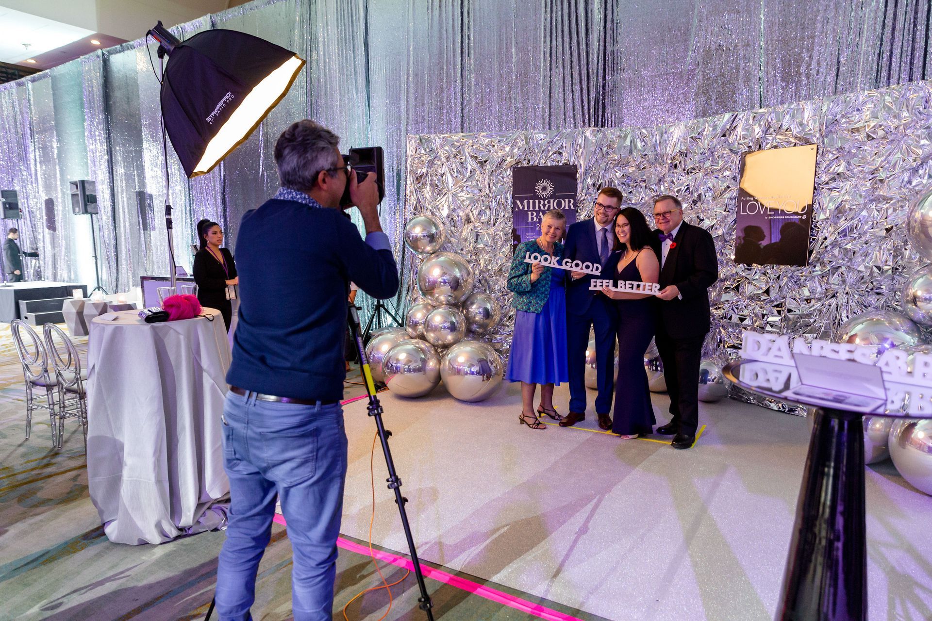 A man is taking a picture of a group of people in a room.