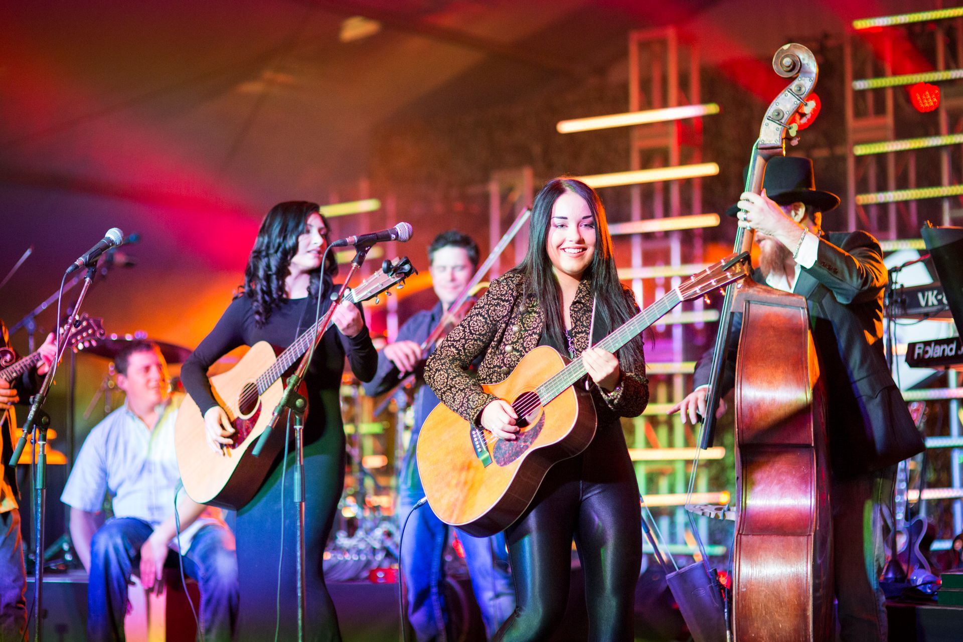 A group of people are playing guitars on a stage.