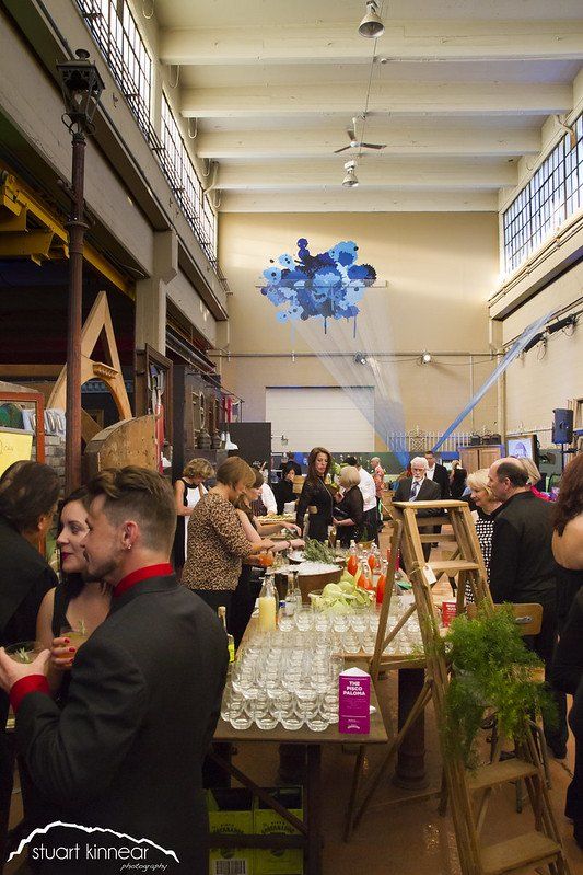 A group of people are standing around a table in a large room.