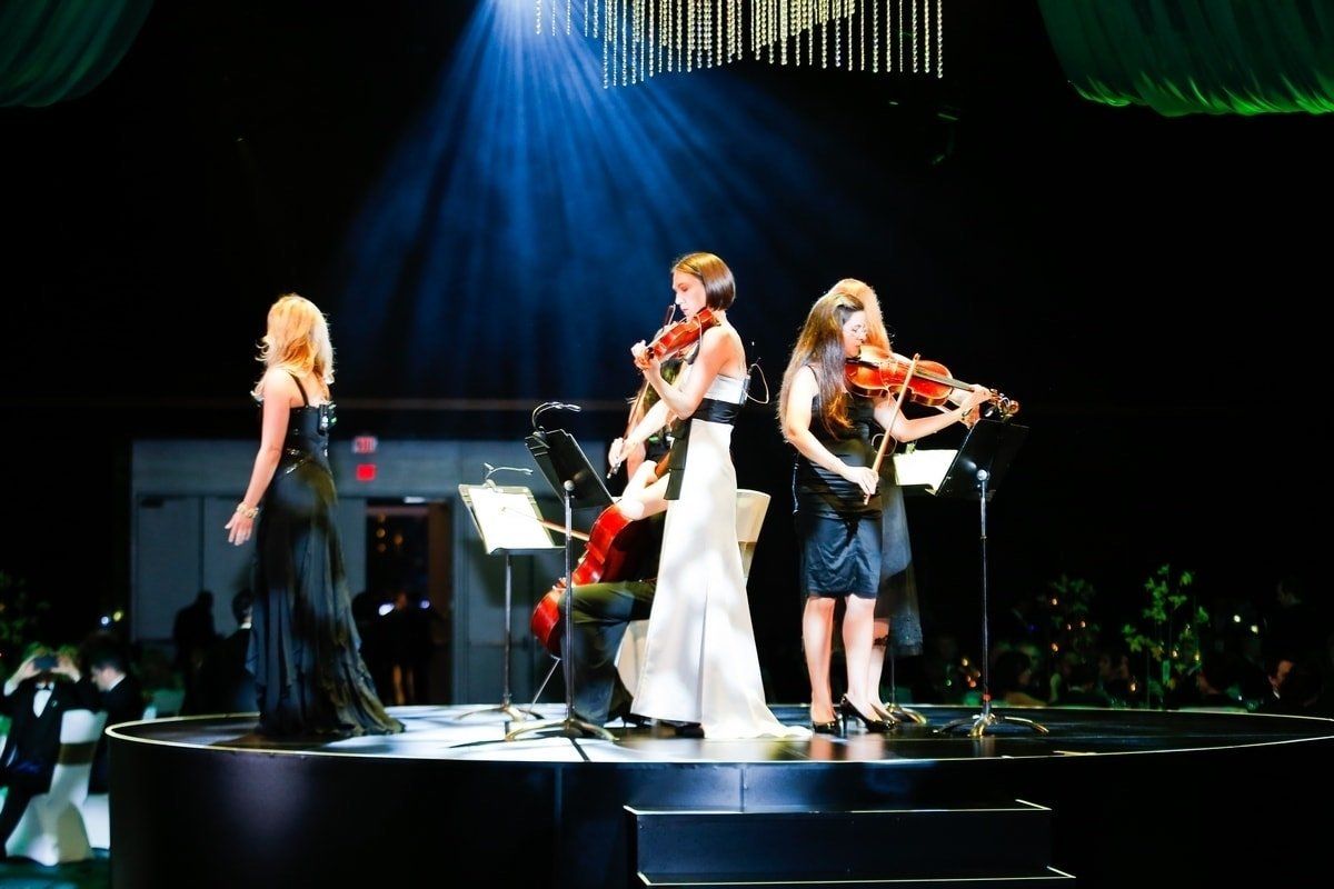 A group of women are playing violins on a stage.