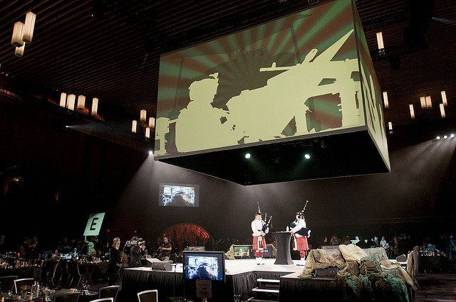 A large screen is hanging from the ceiling in a dark room