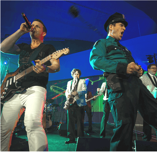 A man singing into a microphone while playing a guitar