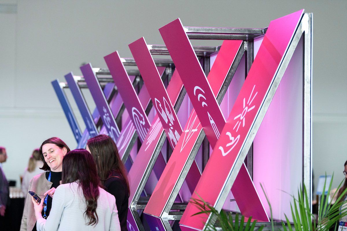 A group of people standing in front of a sign that says ' xerox ' on it