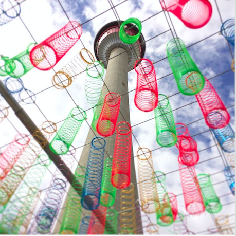 A tower is surrounded by colorful slinky springs