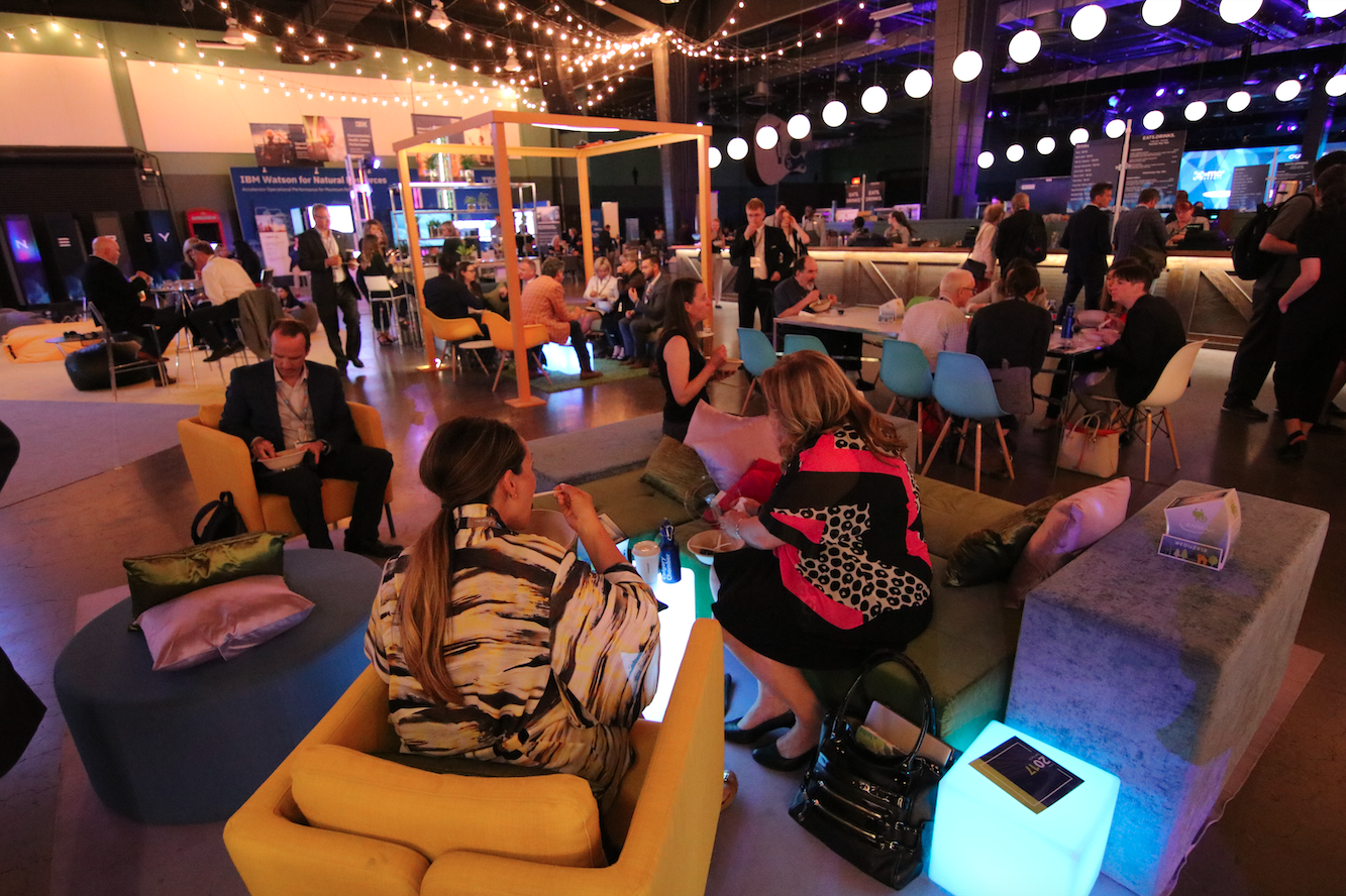 A group of people are sitting in chairs in a large room.
