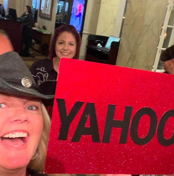 A woman holding a red sign that says yahoo