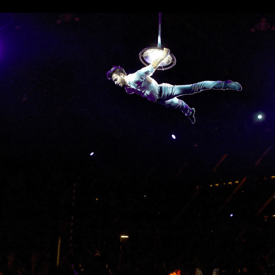 A man is flying through the air in a dark room