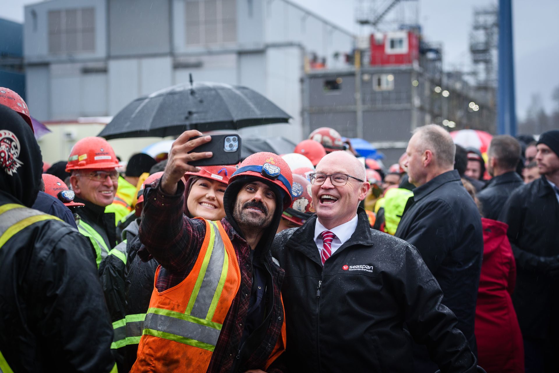 A man is taking a selfie with a group of people.