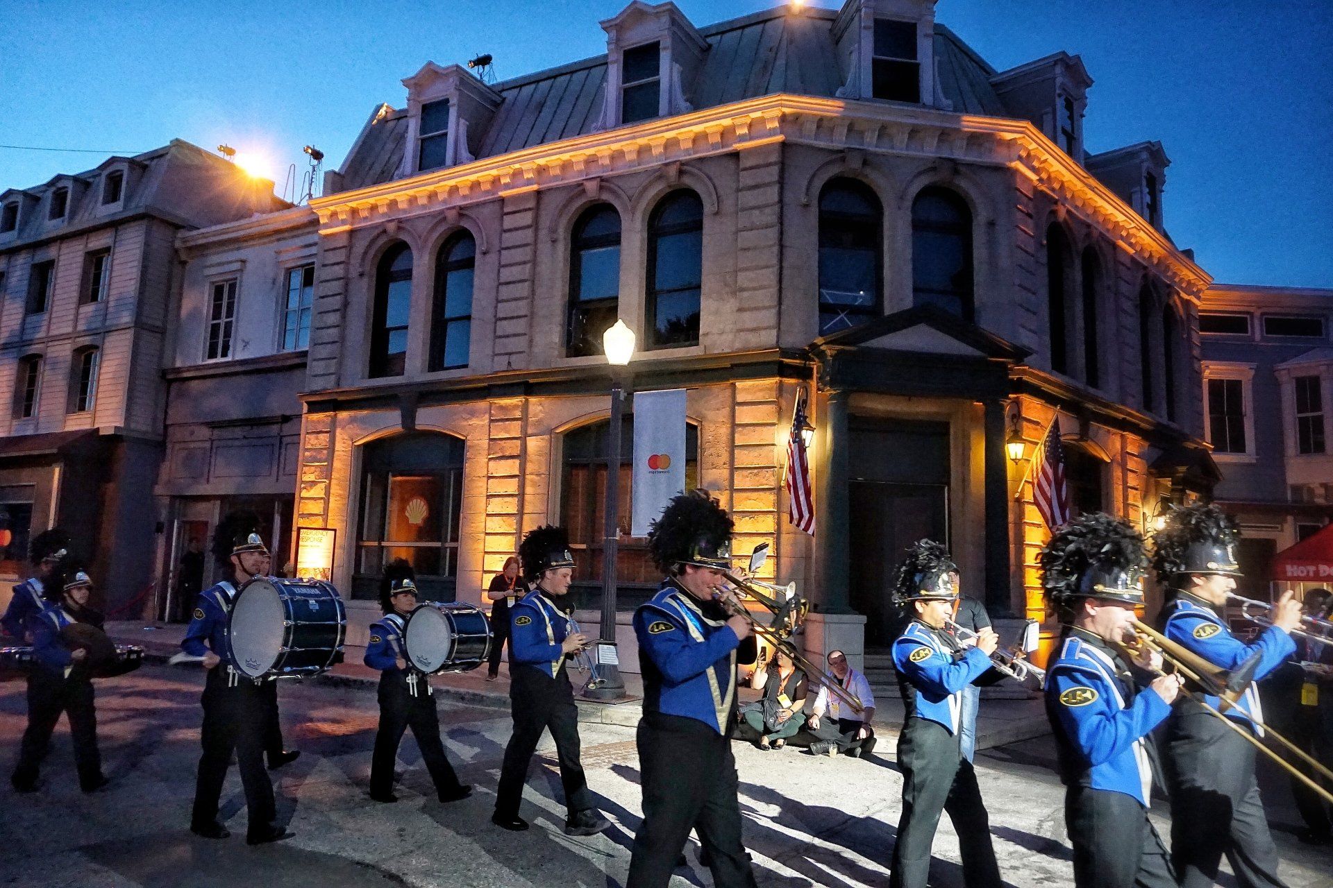 A marching band is marching in front of a building