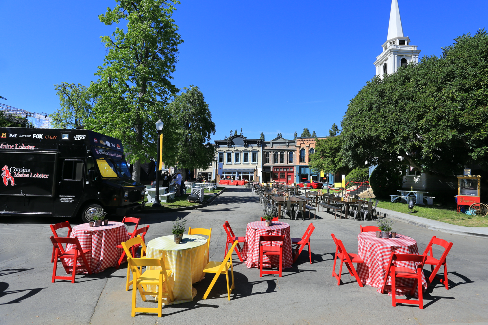 Several tables and chairs are set up in a parking lot