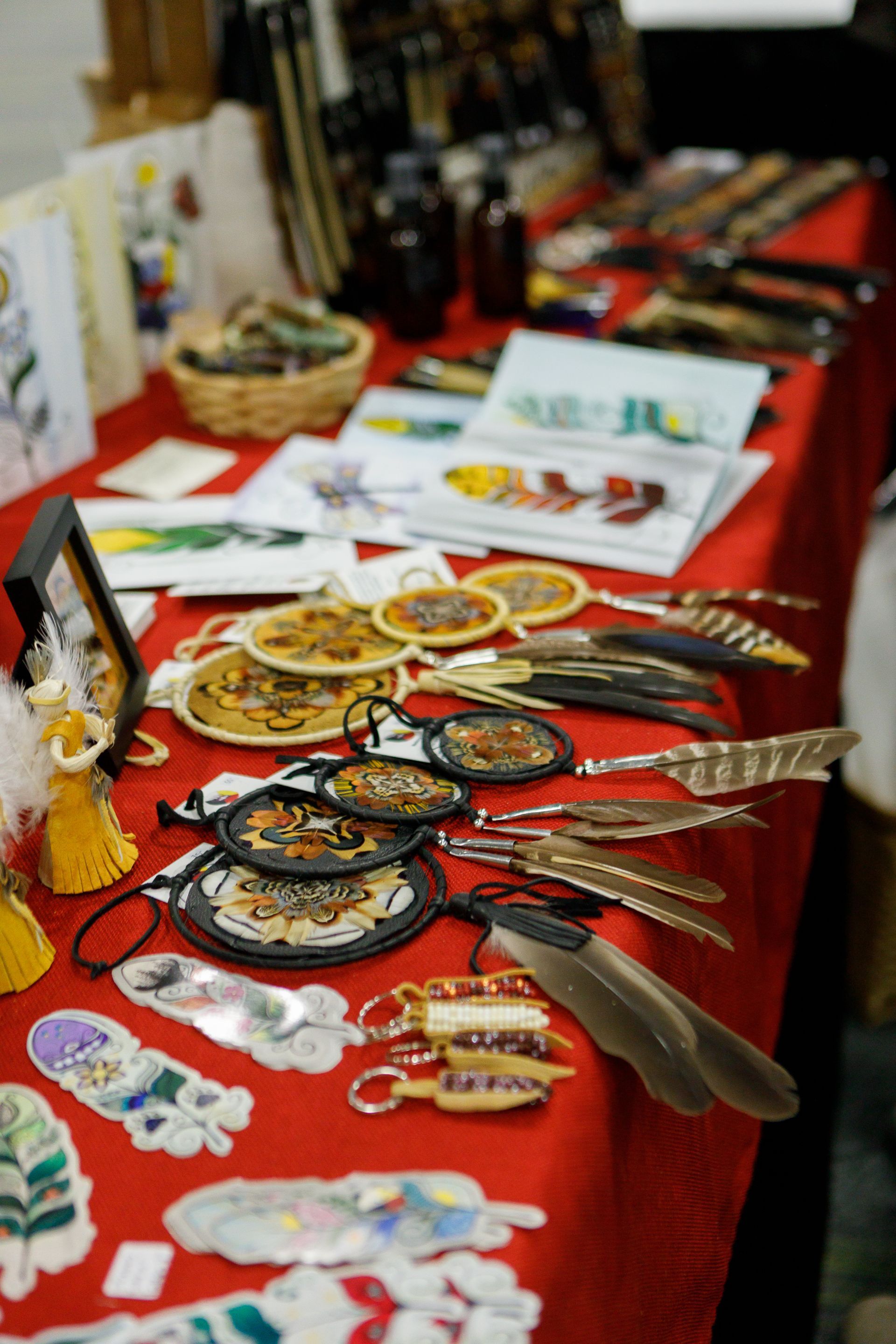 A table with a lot of items on it including dream catchers and feathers
