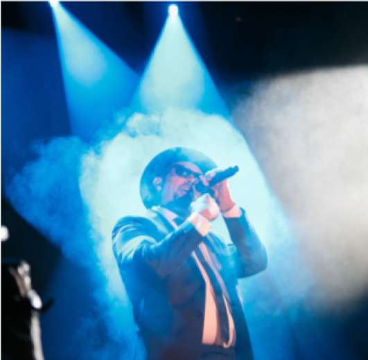 A man singing into a microphone on a stage