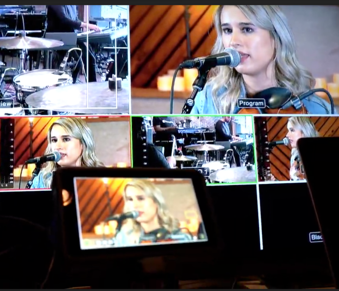 A woman singing into a microphone on a tv screen