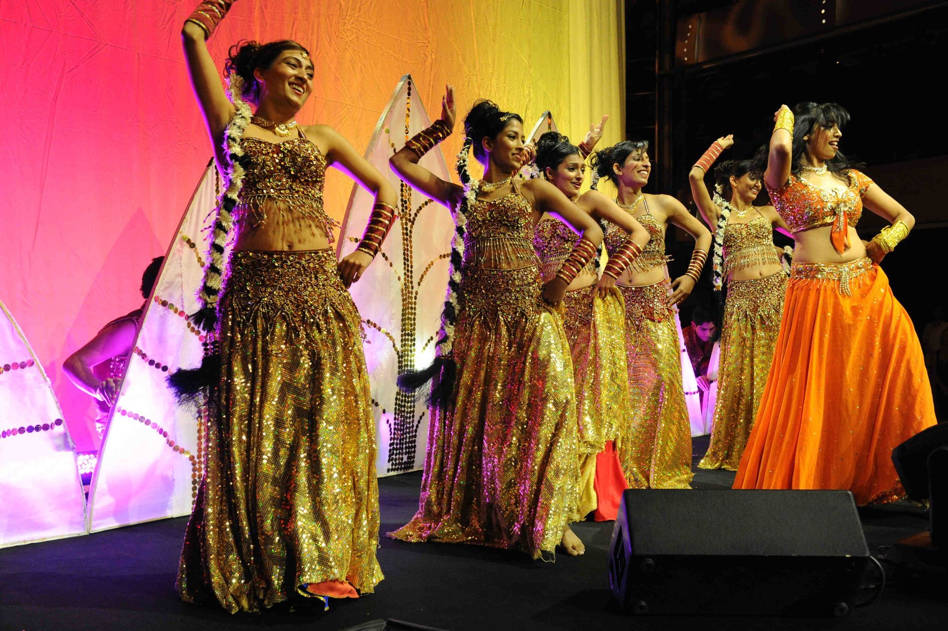 A group of belly dancers are performing on a stage
