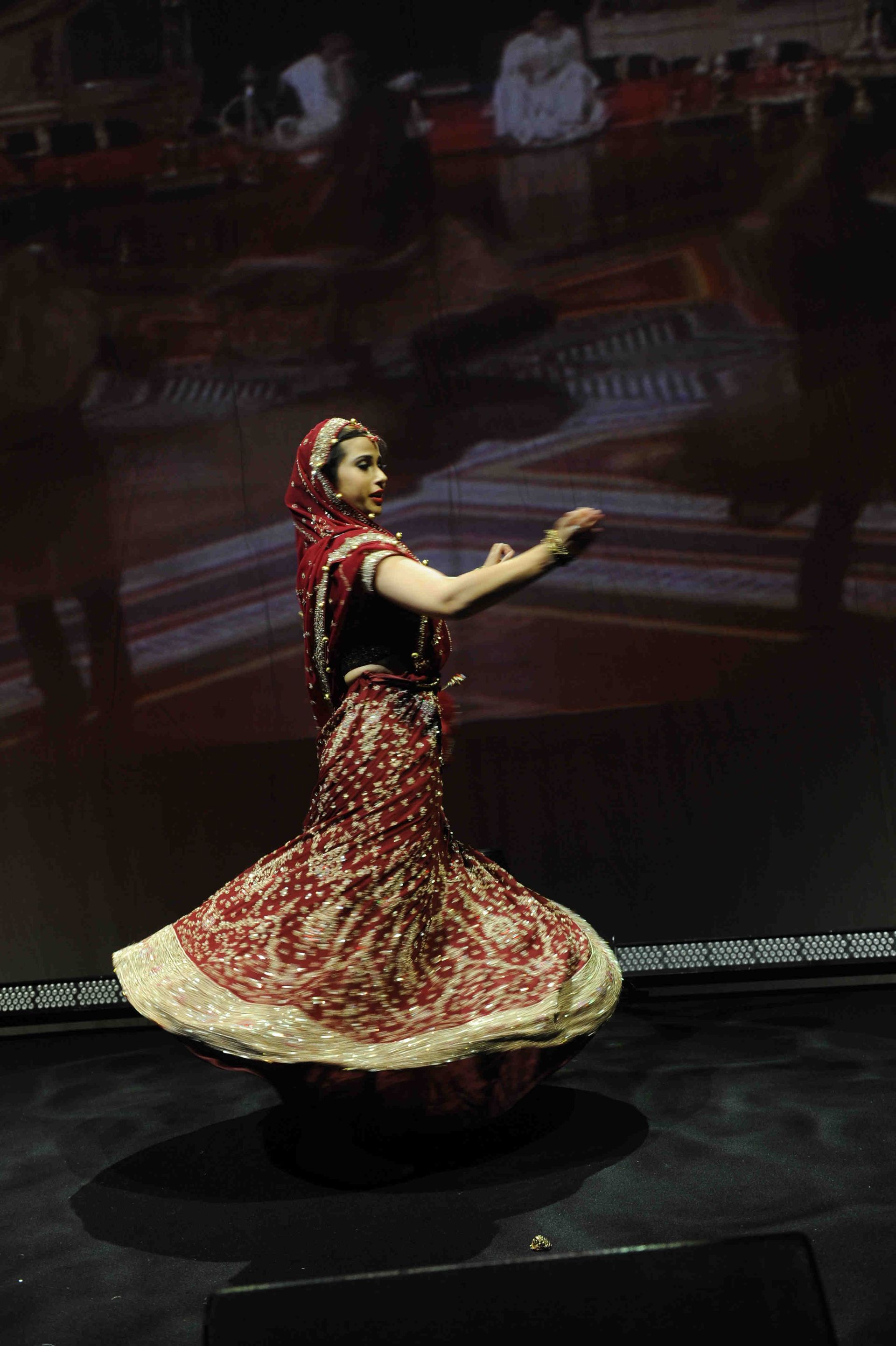 A woman in a red and white dress is dancing on a stage