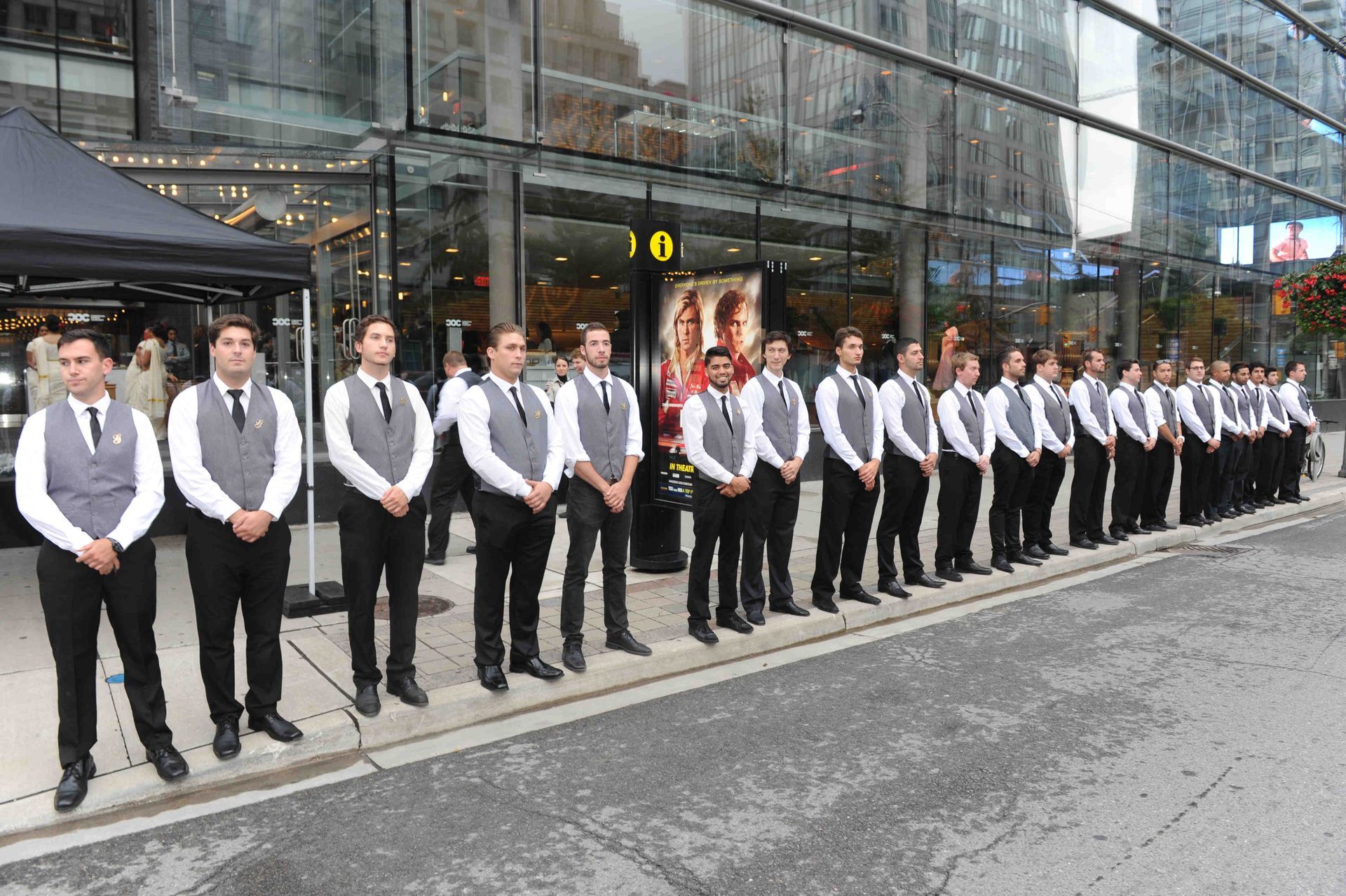 A group of people standing in front of a building holding letters in their hands.