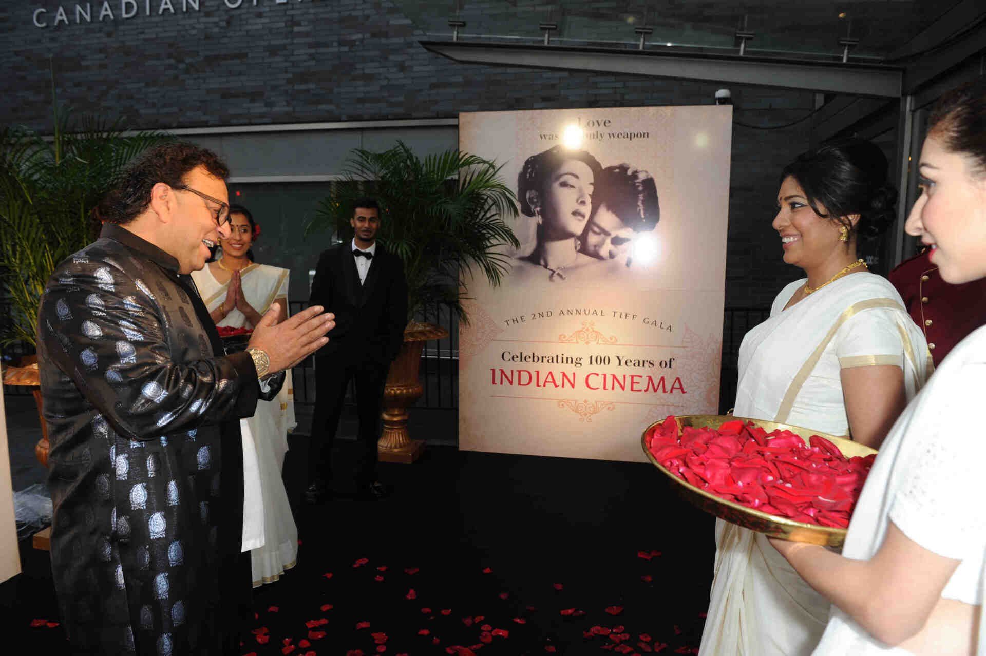 A group of people standing in front of a sign that says indian cinema
