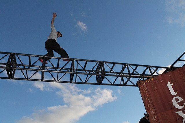 A man is riding a skateboard over a metal structure