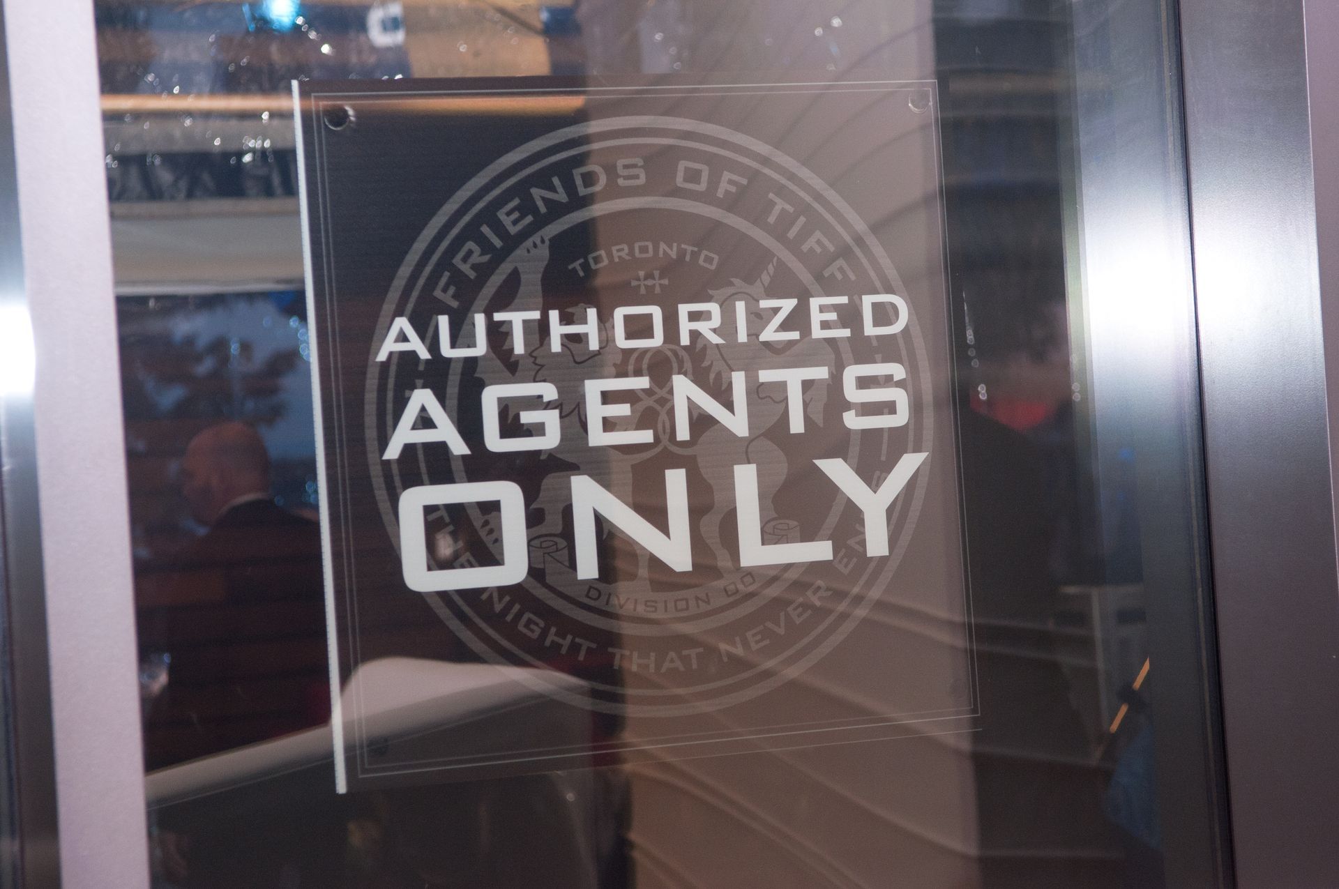 A sign on a glass door that says authorized agents only