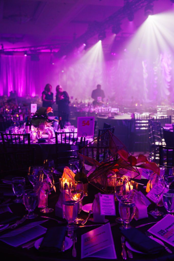 A room filled with tables and chairs and purple lights.