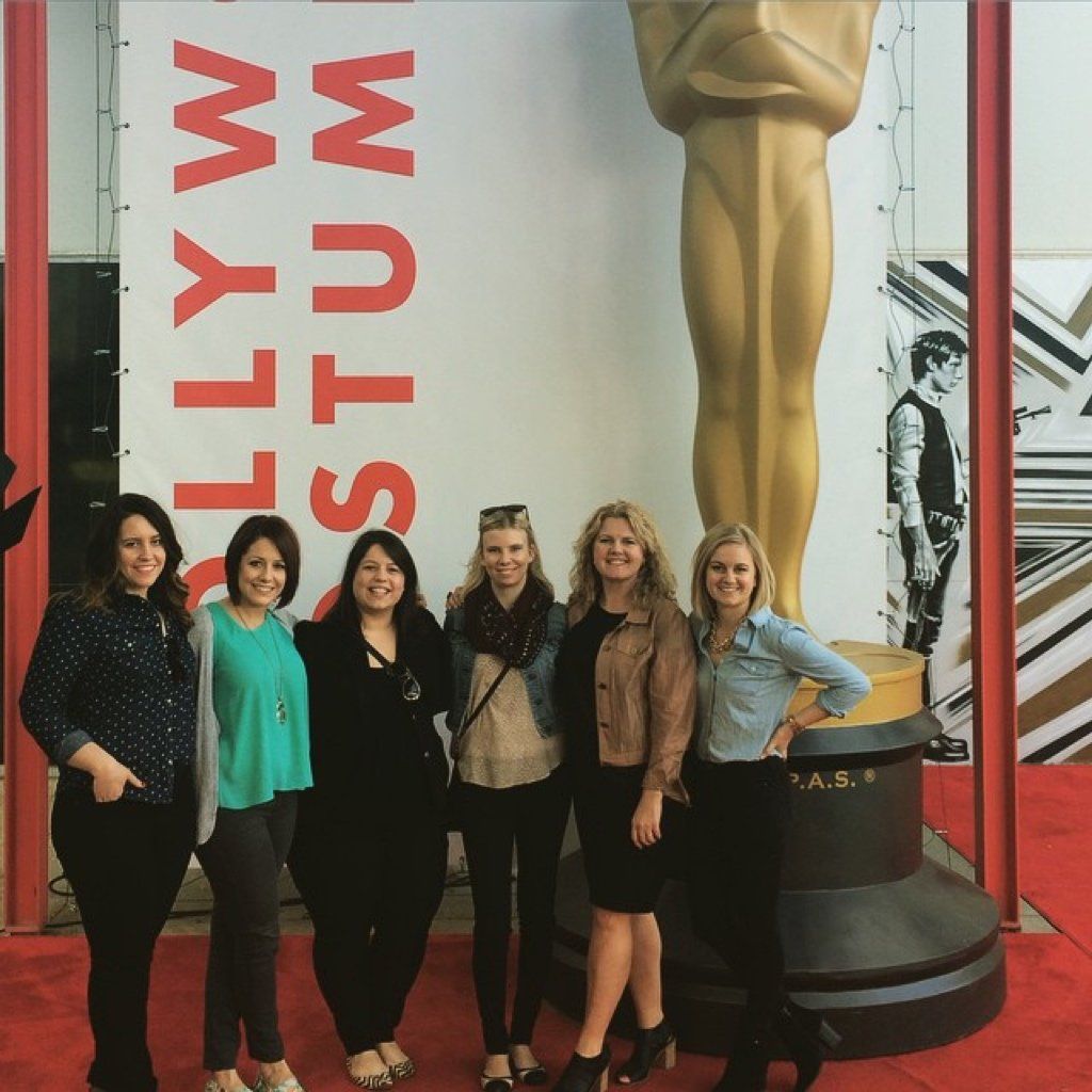 A group of women standing in front of a hollywood stump