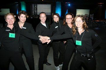 A group of people wearing black shirts are holding hands