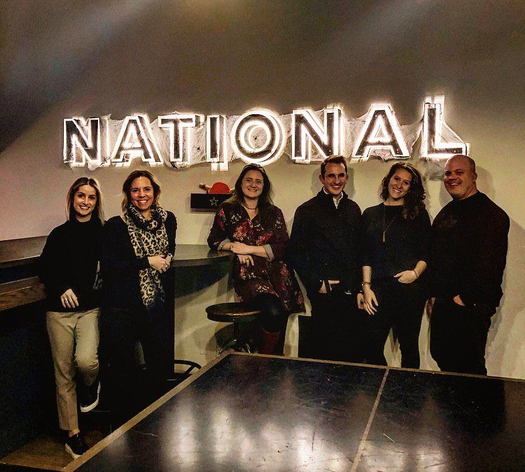 A group of people standing in front of a national sign