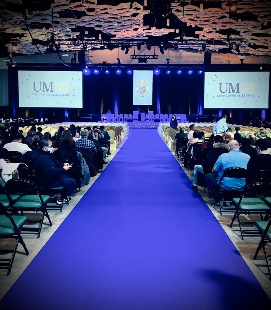 A blue carpet leading to a stage with um written on it