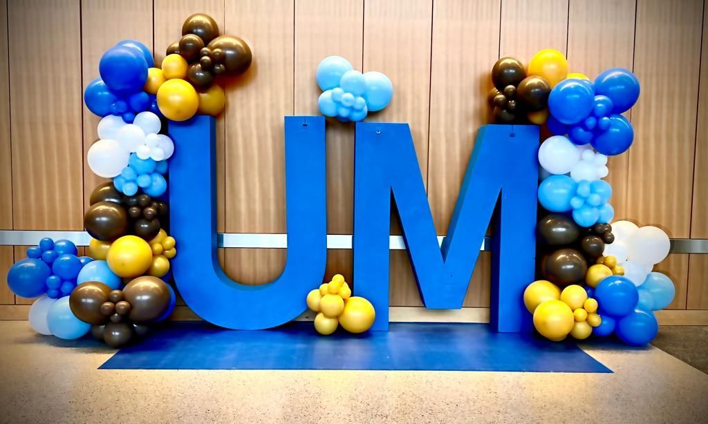 A large blue letter u is surrounded by balloons.