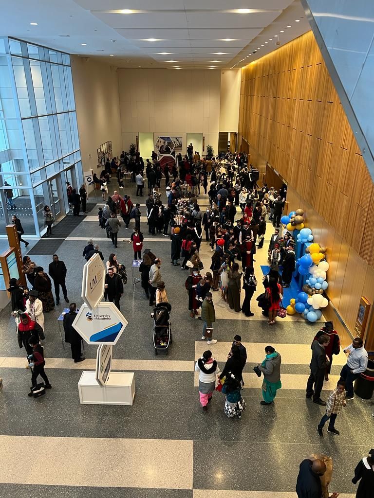 A large group of people are standing in a lobby of a building.