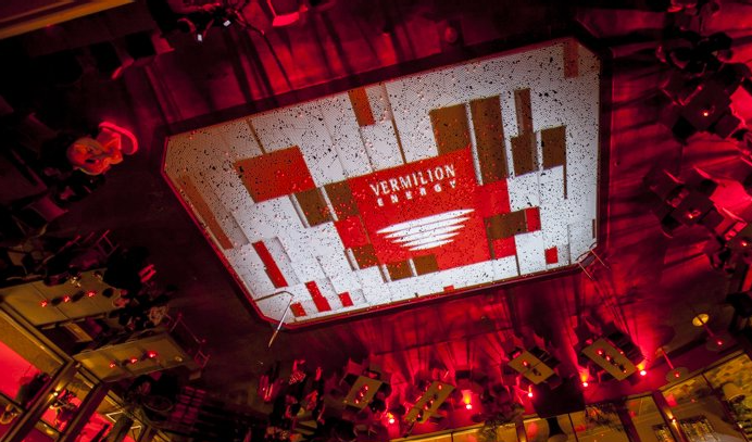 A large screen is hanging from the ceiling of a room.