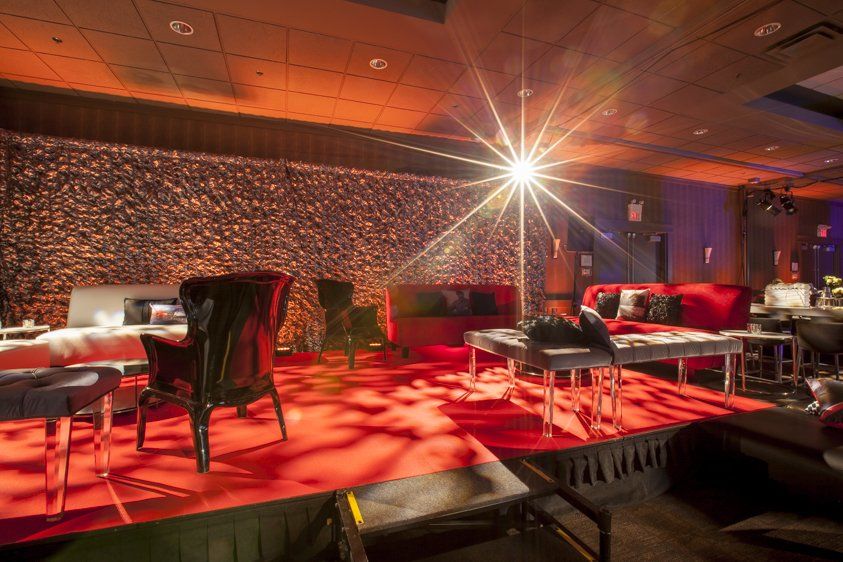 A room with a lot of furniture and a stage in the middle of the room.