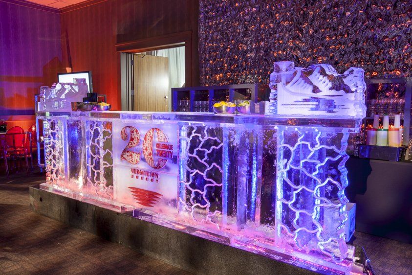 A long ice bar in a room with purple lights.