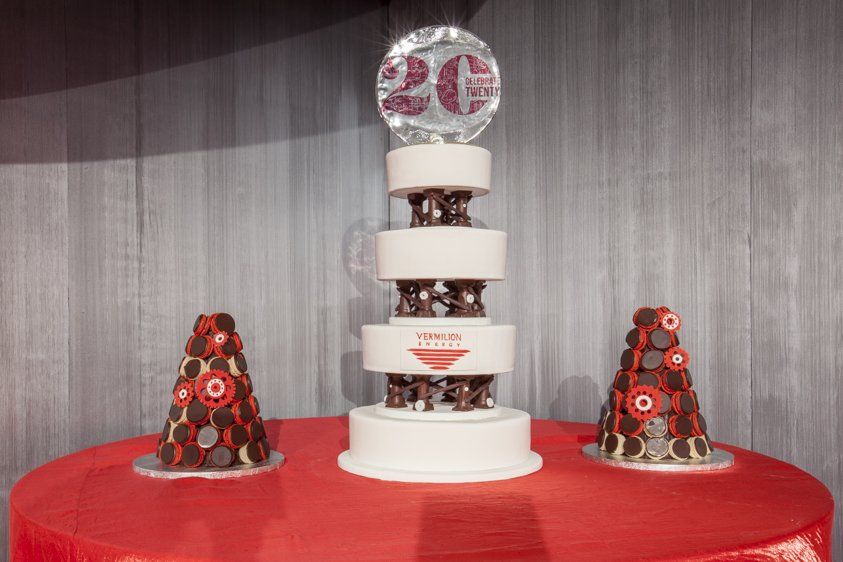 A large cake is sitting on top of a red table.