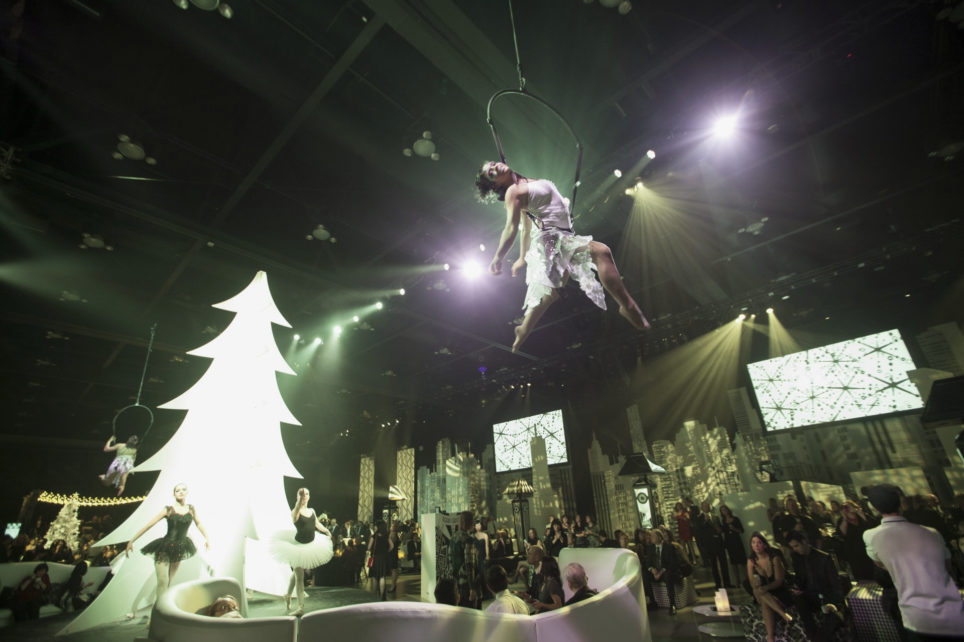 A woman is flying through the air in front of a christmas tree