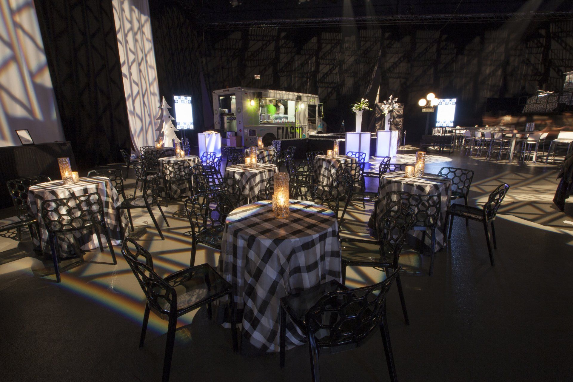 A large room with tables and chairs set up for a party.