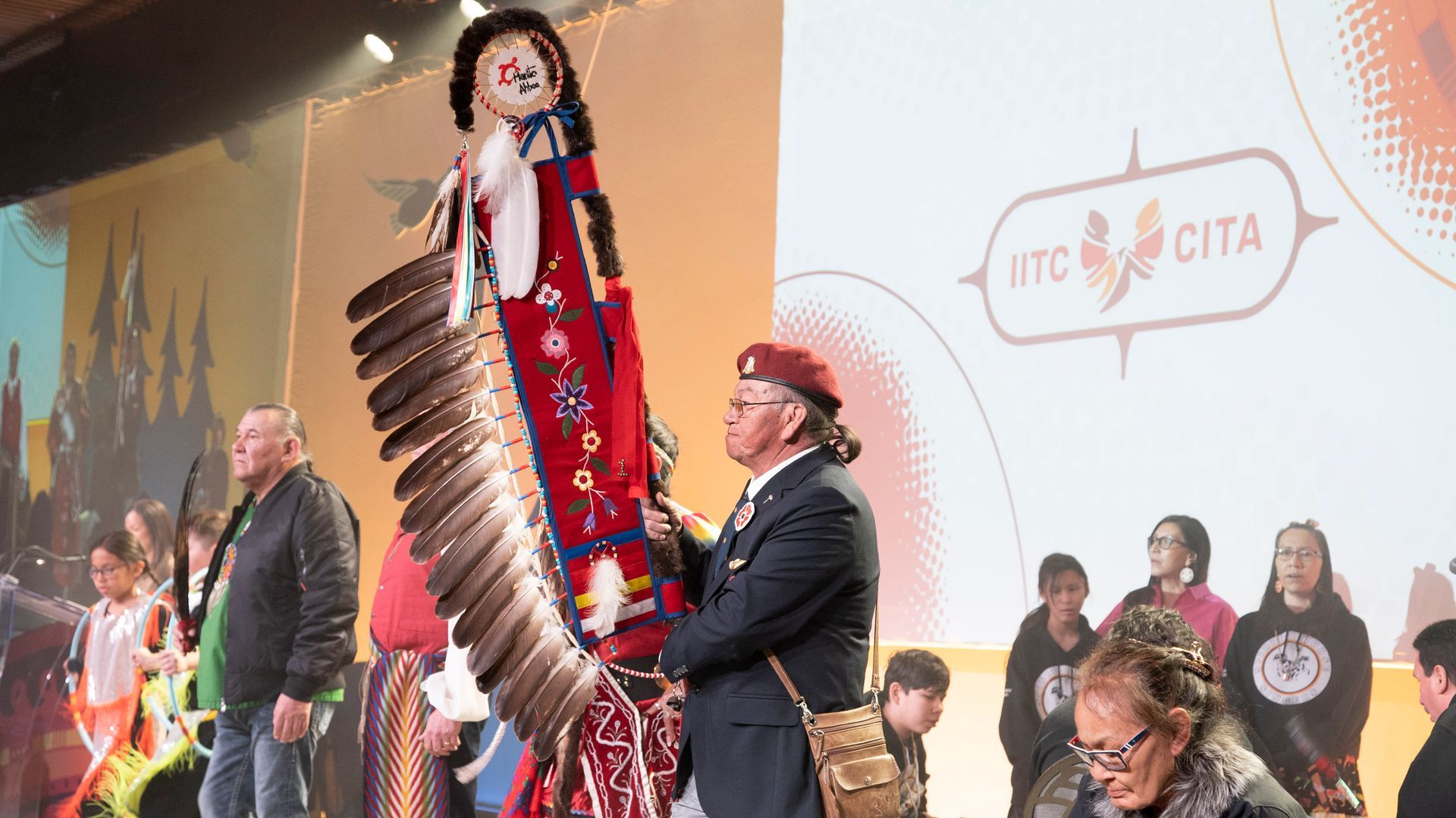 A group of people are standing in front of a stage holding a doll.