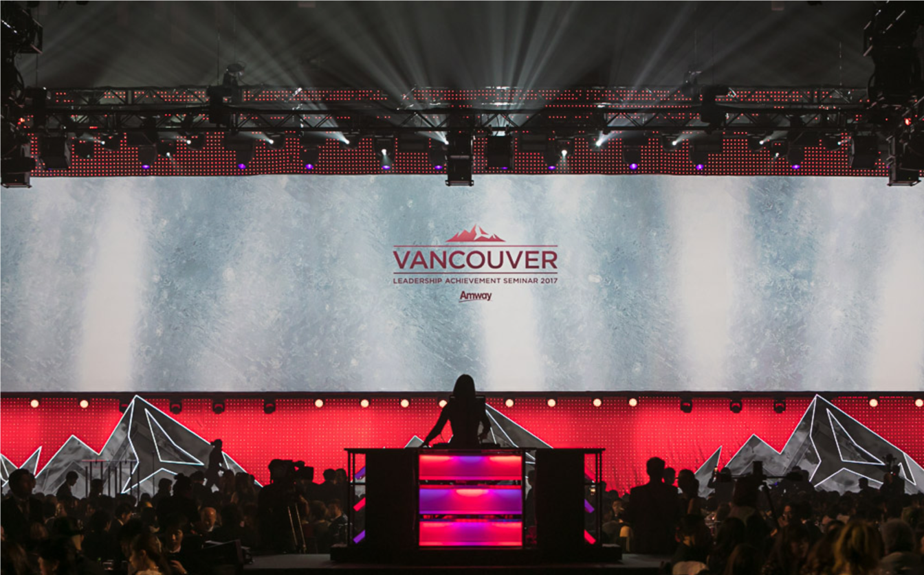 A woman stands on a stage in front of a vancouver sign