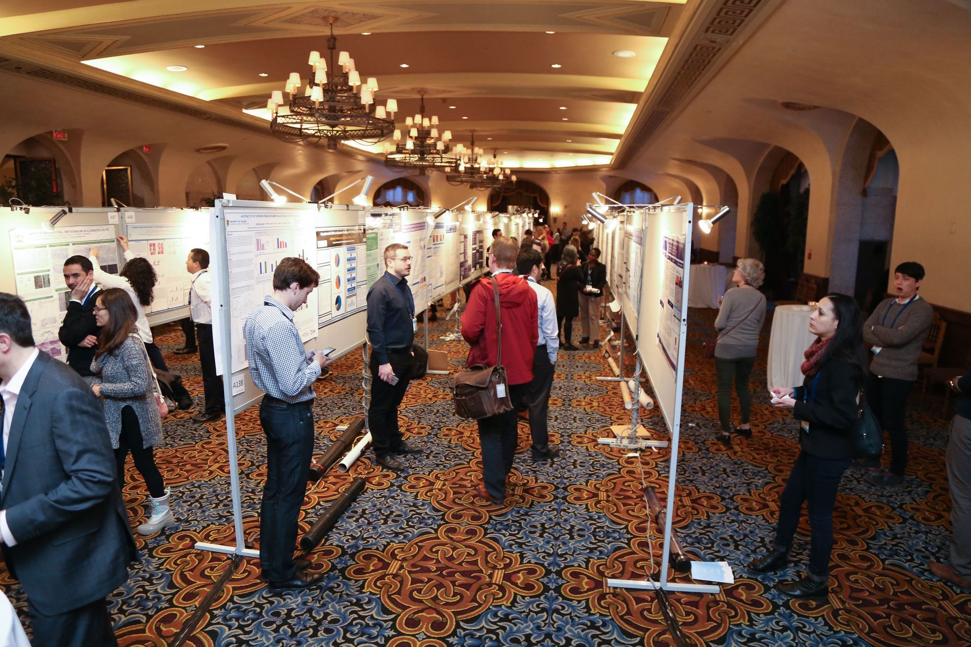 A group of people are standing in a large room looking at posters