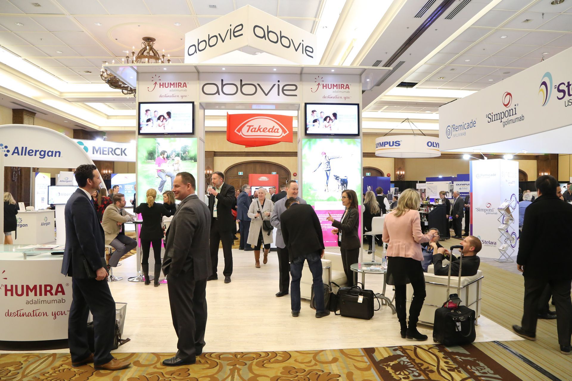 A group of people are standing in front of a booth that says abovie