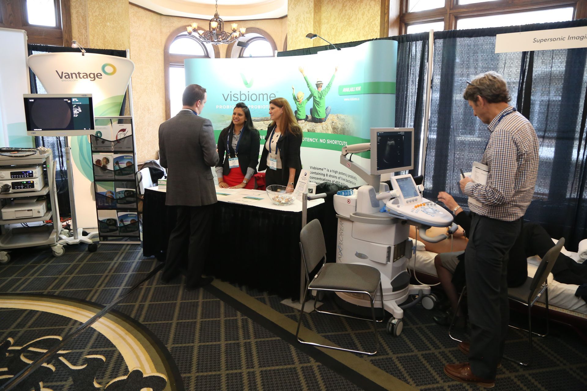 A group of people are standing around a booth at a convention