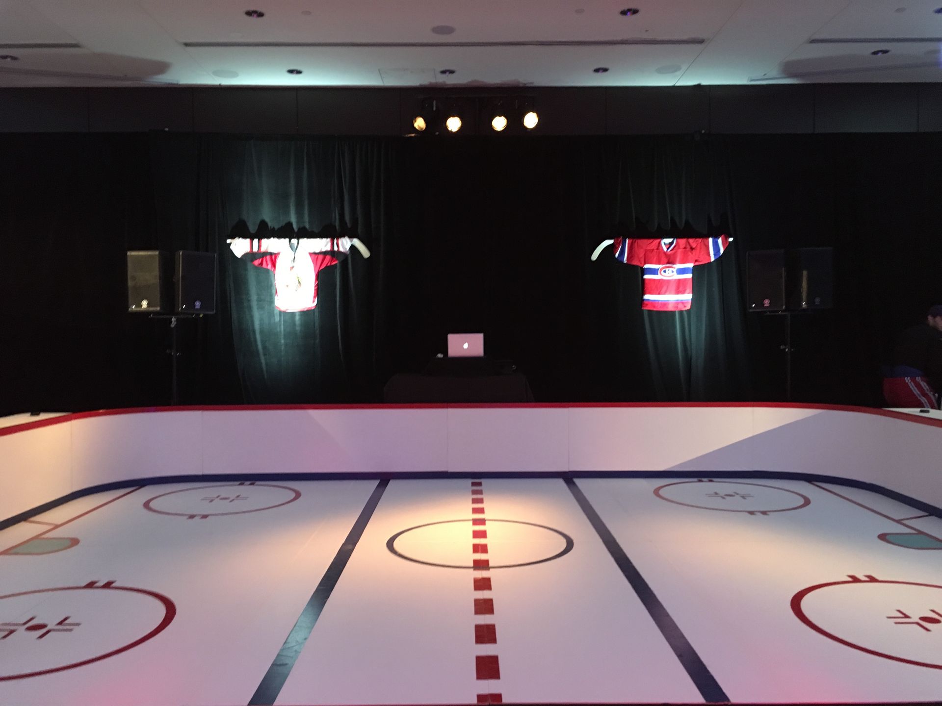 A hockey rink with jerseys hanging on the wall