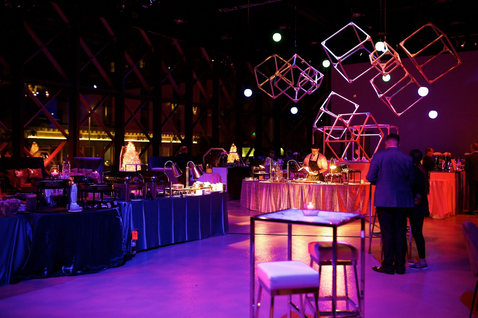 A large room with purple lights and tables and chairs
