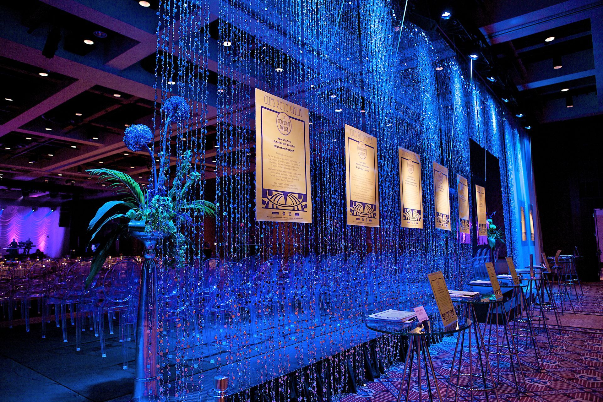 A room with blue lights and tables and chairs